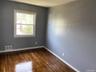 Spare room featuring baseboards and dark wood finished floors