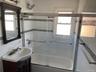 Bathroom featuring plenty of natural light, vanity, and bath / shower combo with glass door