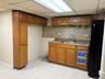 Kitchen with brown cabinets, freestanding refrigerator, a paneled ceiling, tasteful backsplash, and light tile patterned floors