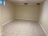 Finished basement featuring a paneled ceiling and light tile patterned floors