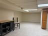 Finished basement featuring a paneled ceiling and baseboards