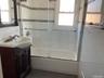 Full bathroom featuring bath / shower combo with glass door, vanity, and plenty of natural light