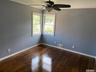 Empty room featuring ornamental molding, dark wood-style floors, and a ceiling fan