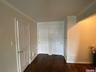 Corridor featuring crown molding and dark wood-style floors