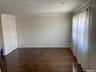 Unfurnished room with dark wood-style floors and crown molding