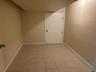 Empty room featuring baseboards and light tile patterned flooring