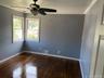 Spare room featuring ornamental molding, dark wood-style floors, and a ceiling fan