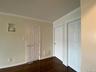Unfurnished bedroom with ornamental molding, dark wood-style floors, and a closet