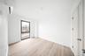 Unfurnished bedroom featuring light wood finished floors and a wall mounted air conditioner