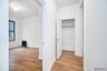 Corridor with a textured ceiling, light wood finished floors, and radiator heating unit