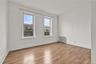 Empty room featuring a decorative wall, radiator, and light wood-style floors