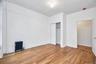 Unfurnished bedroom featuring a textured ceiling, radiator, light wood finished floors, and a closet