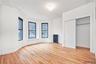 Unfurnished bedroom featuring light wood-style floors, radiator, a closet, and an ornate ceiling
