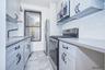 Kitchen with appliances with stainless steel finishes, decorative backsplash, white cabinets, and light tile patterned floors