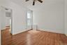 Spare room with light wood-type flooring, ceiling fan, and a decorative wall