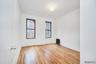Unfurnished room featuring a textured ceiling, light wood finished floors, and radiator heating unit