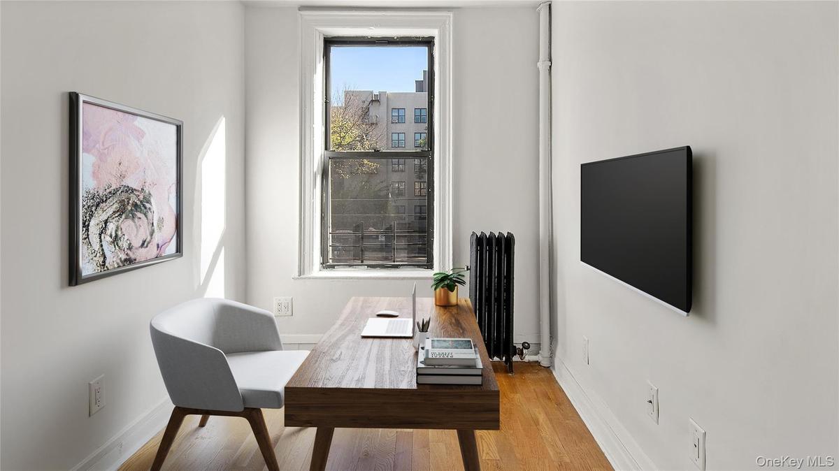 Office area featuring radiator heating unit and wood finished floors