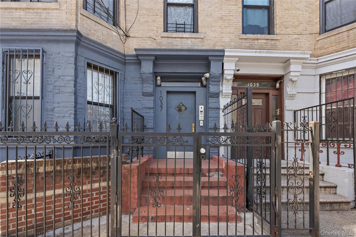 Property entrance with brick siding and a gate