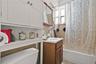 Full bath featuring vanity, shower / tub combo, and tile walls