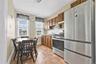 Kitchen with stainless steel appliances, light countertops, decorative backsplash, brown cabinetry, and under cabinet range hood