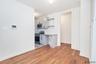 Kitchen featuring appliances with stainless steel finishes, decorative backsplash, light wood-style floors, light countertops, and white cabinetry
