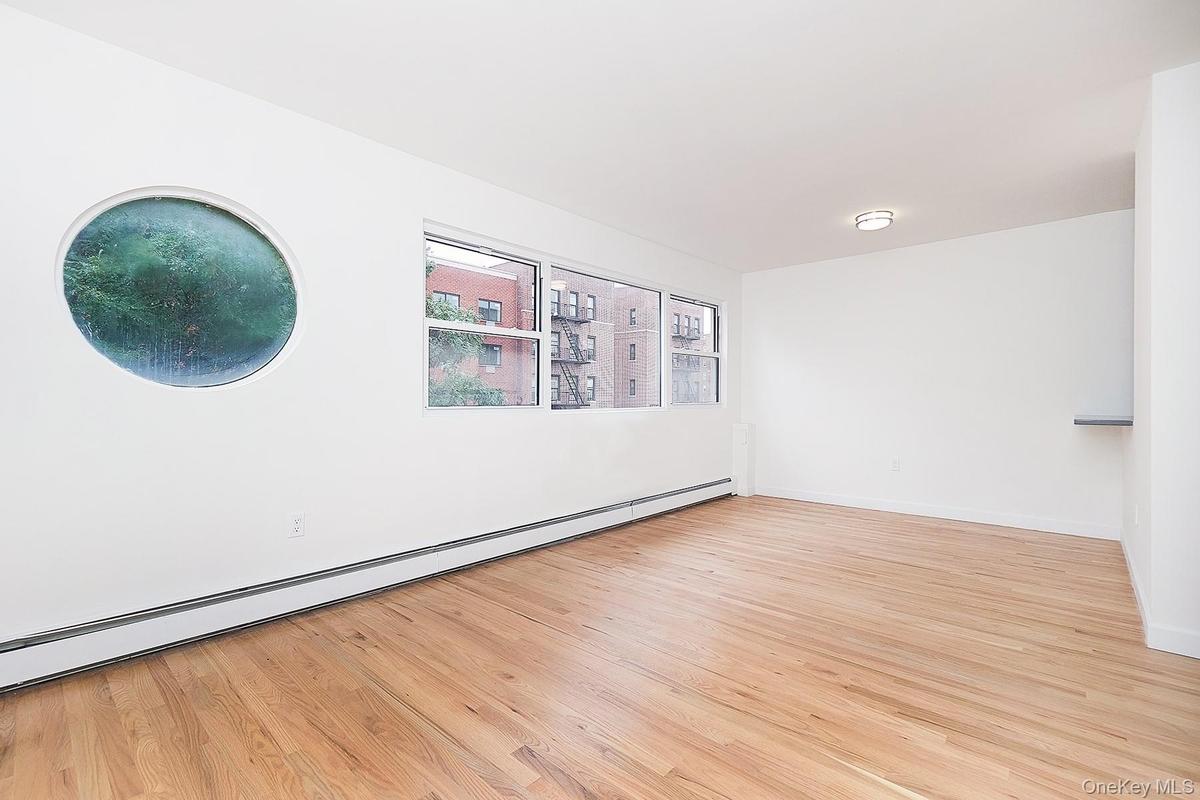 Empty room featuring baseboard heating and light wood-style floors