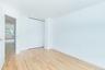 Unfurnished bedroom with light wood finished floors, a closet, and baseboard heating