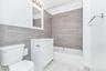 Bathroom featuring vanity, washtub / shower combination, and tile walls