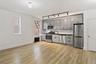 Kitchen featuring stainless steel appliances, light wood-type flooring, gray cabinets, radiator, and dark countertops