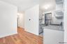 Kitchen with light wood finished floors, appliances with stainless steel finishes, decorative backsplash, gray cabinets, and light countertops