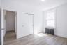 Unfurnished bedroom featuring radiator heating unit, light wood-style flooring, and a closet