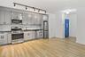 Kitchen featuring appliances with stainless steel finishes, light wood-style flooring, track lighting, gray cabinetry, and backsplash