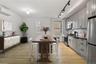 Kitchen with stainless steel appliances, tasteful backsplash, gray cabinetry, a wall unit AC, and light wood-style floors