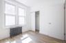 Bedroom featuring radiator, light wood-style flooring, and a closet