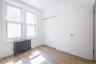 Unfurnished bedroom featuring radiator, light wood-style flooring, and a closet