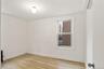 Unfurnished room featuring a wall mounted AC and light wood-type flooring