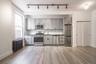 Kitchen featuring radiator, stainless steel appliances, gray cabinets, and tasteful backsplash