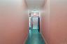Hall featuring baseboards and dark tile patterned flooring