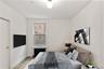 Bedroom featuring radiator heating unit and light wood-style floors