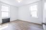 Unfurnished room featuring radiator heating unit, light wood finished floors, and plenty of natural light