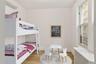 Bedroom featuring radiator heating unit, an AC wall unit, and wood finished floors