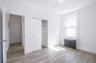 Unfurnished bedroom with radiator heating unit, a closet, and light wood finished floors