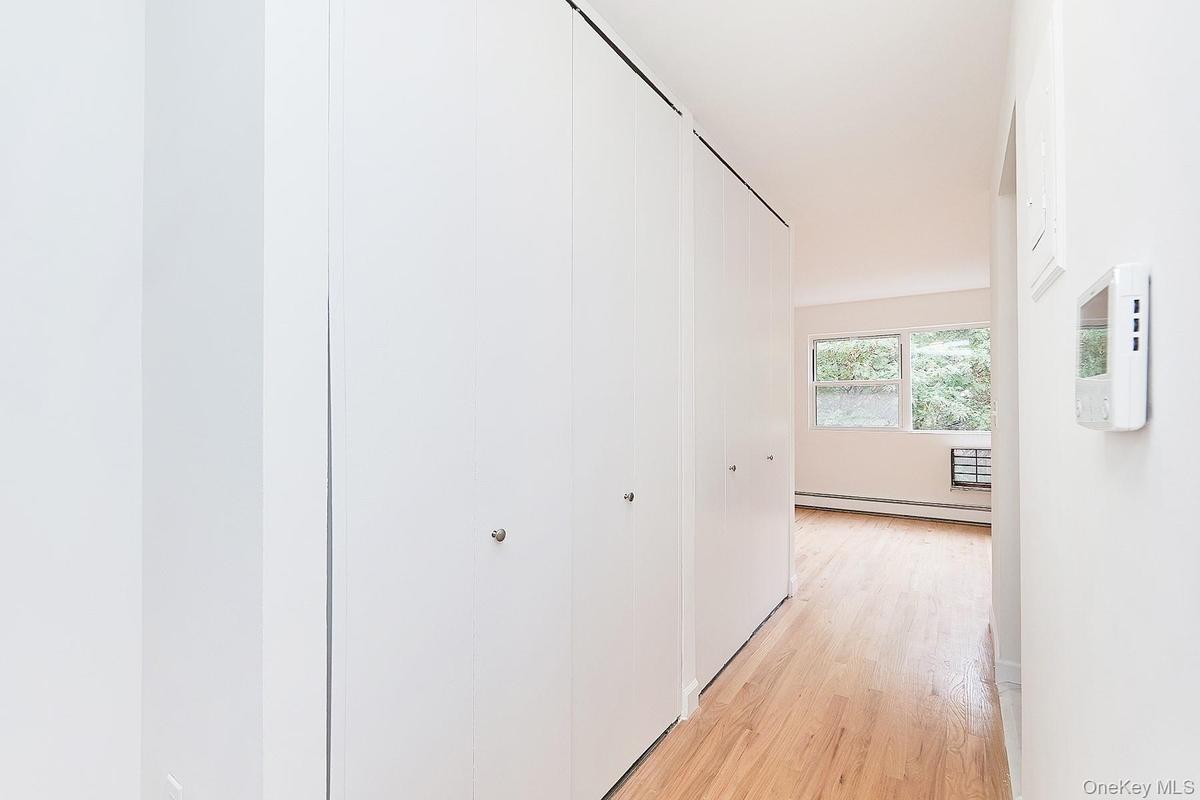 Hallway featuring light wood-style floors and a baseboard heating unit