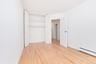 Unfurnished bedroom featuring light wood finished floors, a closet, and a baseboard heating unit