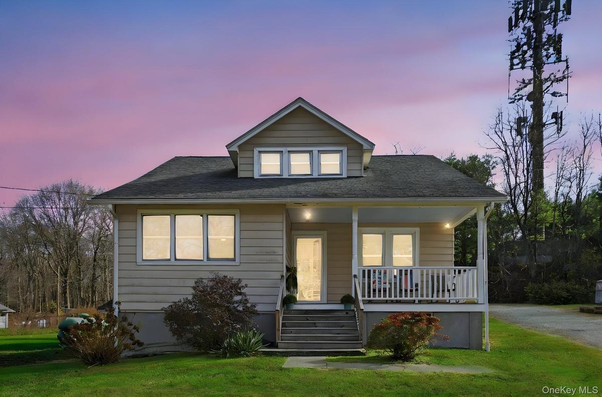 Bungalow-style house featuring covered porch, a front yard, and roof with shingles