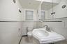 Half bathroom featuring tile walls, tile patterned floors, and a wainscoted wall