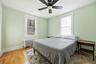 Bedroom featuring radiator heating unit, wood finished floors, and ceiling fan