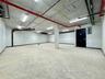 Garage featuring electric panel and baseboards