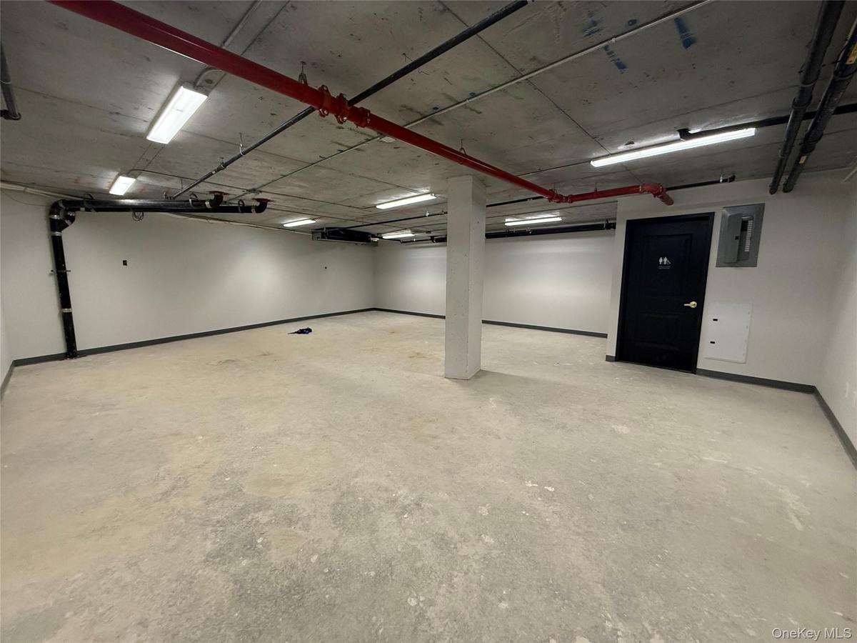 Garage featuring baseboards and electric panel