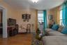 Living area with wood finished floors, ornamental molding, electric panel, and a baseboard heating unit